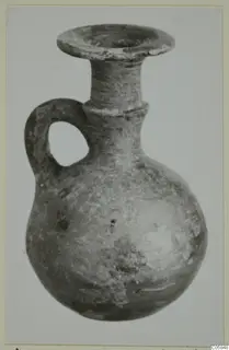 Grey polished ware jug with a round body, narrow neck, flared rim and loop handle