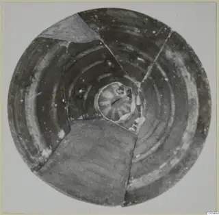 Pottery lid from Amathus, seen from above, with concentric pale bands around a central knob, mended from fragments