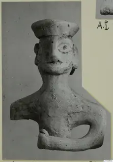 Terracotta figurine of a head and upper body with a flat cap, photographed on a grey card mount