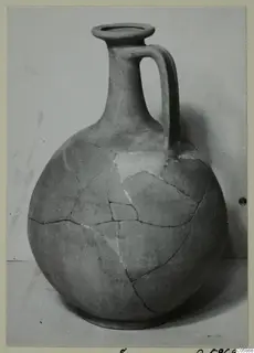 Round-bodied jug with a tall neck and single loop handle, mended from sherds, from Idalion