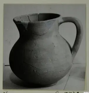 Cypro-Hell. II jug with a single loop handle and a rounded body, photographed on a plain surface.