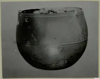 Rounded glass vessel from Idalion with a wide, broken mouth and two horizontal bands around its body