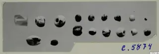 Group of small round beads and a few irregular jewellery parts, shown on a grey background