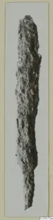 Iron weapon, long and narrow, heavily corroded and pitted, shown upright against a pale background.