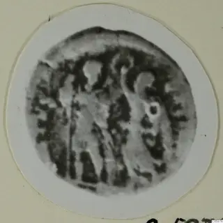Blurred round object with worn raised markings, mounted on a white circular card in a cream frame