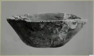 Shallow bowl in cast glass from Idalion, seen from the side against a plain grey background