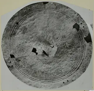 Round bronze disc, possibly a shield, with concentric ridged bands and holes around the rim, from Idalion