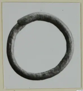 Bronze earring, a plain closed ring with a thickened join, photographed on a pale card.