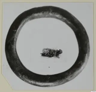 Bronze bracelet, a plain closed ring, lying flat on a pale background.