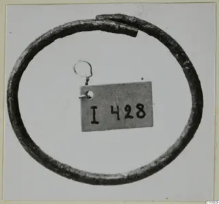 Bronze bracelet from Idalion, an open ring with overlapping ends, shown against a pale background
