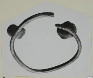 Bronze bracelet from Idalion, an open ring with knob-shaped ends, photographed on a pale background.