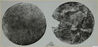 Two round bronze mountings side by side, one intact and one broken across its middle.