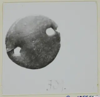 Bronze mounting fragment: a flat disc with two round holes near its edge