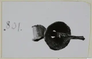 Bronze mounting fragments: a corroded disc with a rod passing through its central hole, and a small socket piece