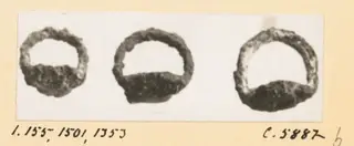 Three corroded iron rings shown side by side on a photographic mount, from Idalion