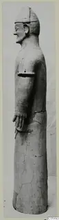 Terracotta statue of a standing figure in side view, with a close-fitting cap and one arm bent at the waist.