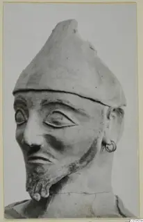Terracotta head and upper bust of a bearded figure in a conical cap with a ring earring