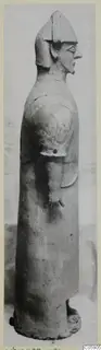 Terracotta standing figure seen in profile, with a helmet-like headdress and long robe, from Ayia Irini