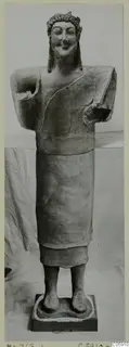 Terracotta Cypro-Greek statue from Mersinaki, a standing figure with a wreath-like headband and damaged arms.
