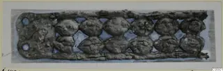 Bronze horse-trappings from Idalion: a corroded rectangular strip with two rows of round bosses and diamond-shaped openings
