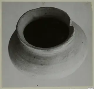 Plain white pottery vessel with a wide mouth and rounded body, seen from above.