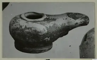 Terracotta lamp from Idalion with a wide filling hole and a long nozzle, seen from the side