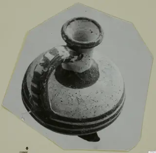 Pottery White Painted II vessel with a flaring rim, short neck and strap handle, shown on a card mount