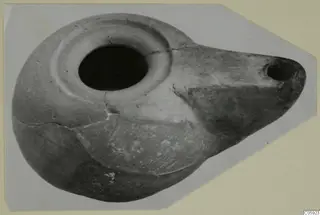 Terracotta oil lamp from Amathus with a wide central filling hole and a long nozzle with a small hole at right.