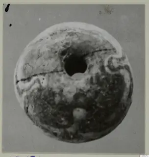 Round bead with a large central hole, photographed face-on against a grey background