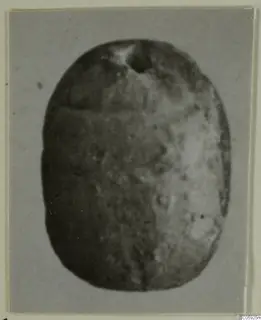 Oval scarab-shaped seal from Idalion, dark and worn, with a perforation near the top edge.
