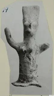 Terracotta figurine with a tall body, one arm raised and a flat base, mounted on a card