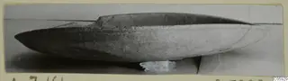Shallow pottery plate from Amathus, shown in side view on a plain grey surface