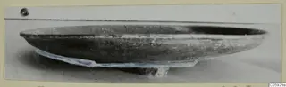 Shallow pottery plate from Amathus, tombs 1–9, photographed from the side.
