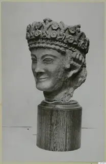 Carved limestone head of a woman wearing a flower-decorated crown, from Vouni, mounted on a wooden base