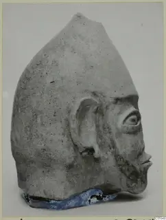 Terracotta head in profile from Ayia Irini, with a tall pointed top, a modelled ear and a moulded beard