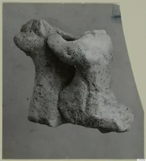 Terracotta minor plastic animal figurine, pale and porous, shown on a grey card mount