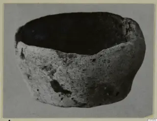 Terracotta lamp, a rounded open vessel with a dark interior, shown on a grey background