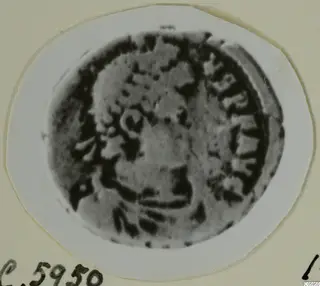 Worn bronze coin from Idalion, photographed close up on a white oval card mount.
