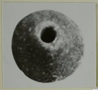 Round grey object with a large central perforation, a bead-like piece of jewellery from Idalion