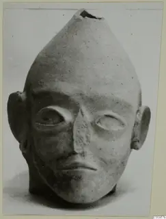 Terracotta head with a tapering top, a ragged opening at the crown, and large almond-shaped eyes; Terracotta Proto-Cypriote I