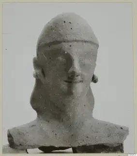Terracotta bust of a man with a high rounded cap, photographed head-on against a plain background