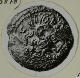 Disc-shaped find from Idalion with raised relief pattern, shown on a white card mount