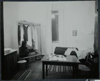 Room of Johns Lindros and Eriks Sjöqvist in Nicosia, with clothes hanging on a rack and a table by the window.