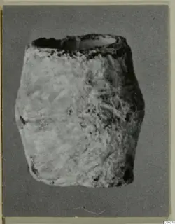 Squat lead container with an open top, photographed against a plain grey backdrop.