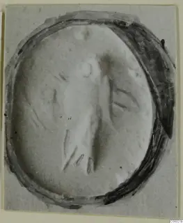 Oval seal or gem, close up, with a carved design of an upright central motif and curved lines