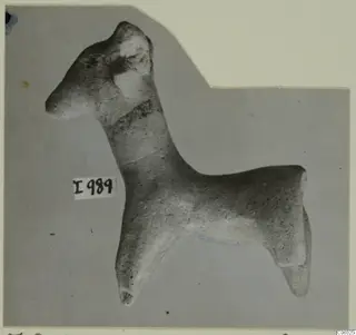 Terracotta figurine of a standing four-legged animal with a long neck and upright ears, shown in profile