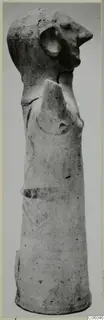 Terracotta figurine from Ayia Irini with a head bearing a large round ear and a tall, tapering cylindrical body