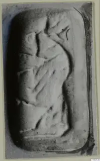 Engraved stone seal with rounded corners, photographed close up on a grey background
