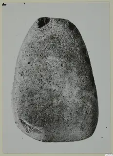 Egg-shaped grey stone object, a small find, photographed against a plain pale background.