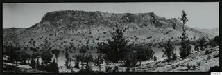 Flat-topped rock ridge at Fylleri, Kythrea, with scrub trees and a stretch of water below it